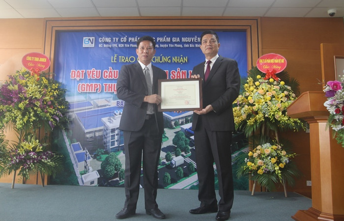 Ông Nguyễn Thanh Phong (phải), Cục trưởng Cục An toàn thực phẩm – Bộ Y tế cấp giấy chứng nhận đạt yêu cầu “thực hành sản xuất tốt” (GMP) thực phẩm bảo vệ sức khỏe cho Công ty Cổ phần Dược phẩm Gia Nguyễn, có địa chỉ tại Khu công nghiệp Yên Phong (Bắc Ninh). Ảnh: Minh Chí.