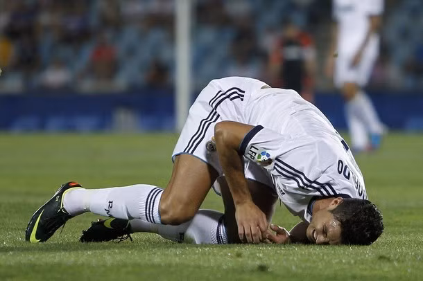 Đổ gục xuống sân.