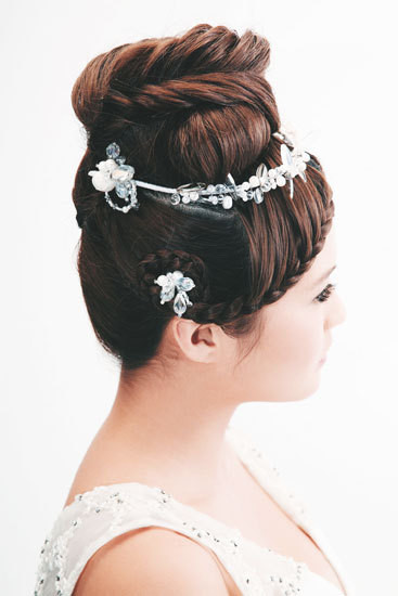 Búi tóc cao bồng bềnh với những nếp uốn, thêm cài đá trắng vô cùng trang trọng quý phái. Búi tóc cao bồng bềnh với những nếp uốn, thêm cài đá trắng vô cùng trang trọng quý phái.