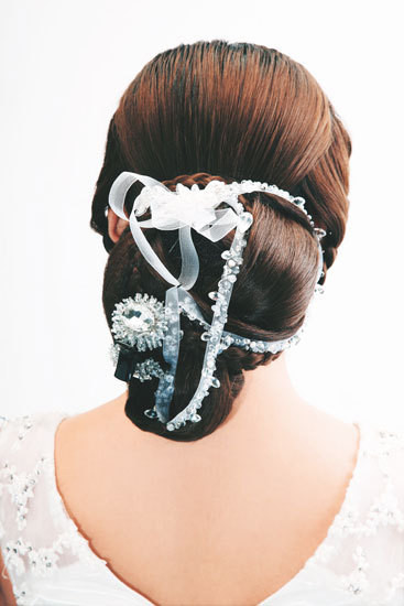 Phía sau không cầu kỳ với những tết tóc nhưng búi tóc lại rất công phu với những đường cong to nhỏ, những dải lụa trang trí đánh vỡ sự tĩnh lặng của kiểu tóc. Phía sau không cầu kỳ với những tết tóc nhưng búi tóc lại rất công phu với những đường cong to nhỏ, những dải lụa trang trí đánh vỡ sự tĩnh lặng của kiểu tóc.