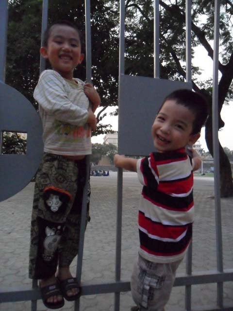 Hai đứa trẻ hân hoan chơi trò đu cổng và “chui ra chui vào”. Hai đứa trẻ hân hoan chơi trò đu cổng và “chui ra chui vào”.