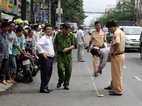 Cảnh sát giao thông đo đoạn đường nạn nhân bị xe buýt kéo lê trên đường. Ảnh: vne