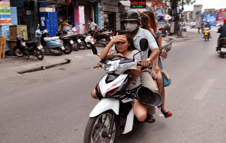 Cá biệt có những trường hợp chở ba có mũ bảo hiểm nhưng không đội....