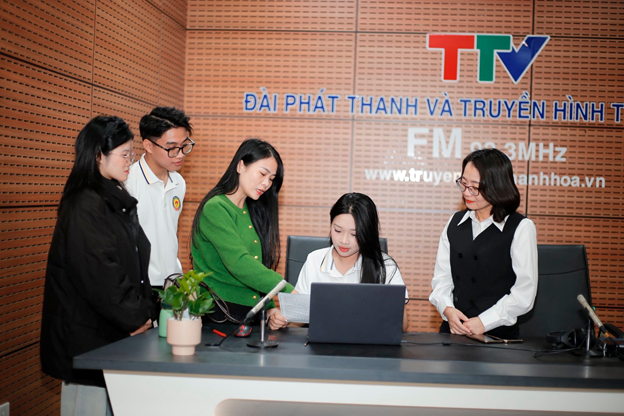 Sinh viên được hướng dẫn trải nghiệm phòng thu âm các chương trình bản tin phát thanh. Ảnh: HDU