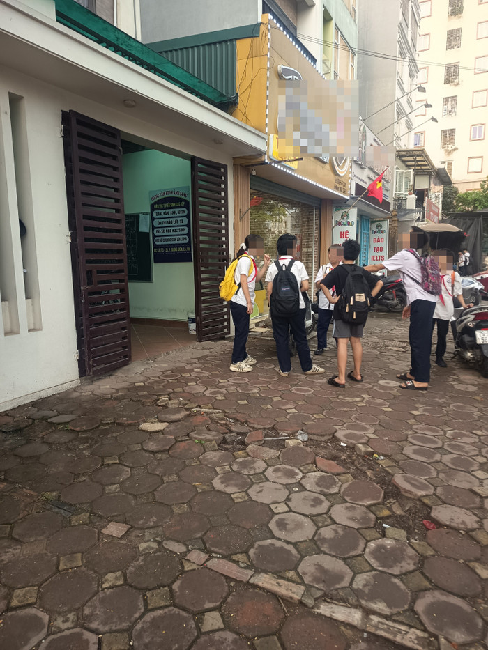 Một nhóm học sinh đứng nói chuyện trong khi đợi giáo viên đến dạy. hoc-sinh-thcs-giang-bien-hoc-them-9069.jpg