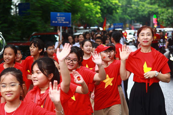 Các em học sinh và giáo viên chào người dân đi đường. he-thong-giao-duc-ly-thai-to-4.jpg