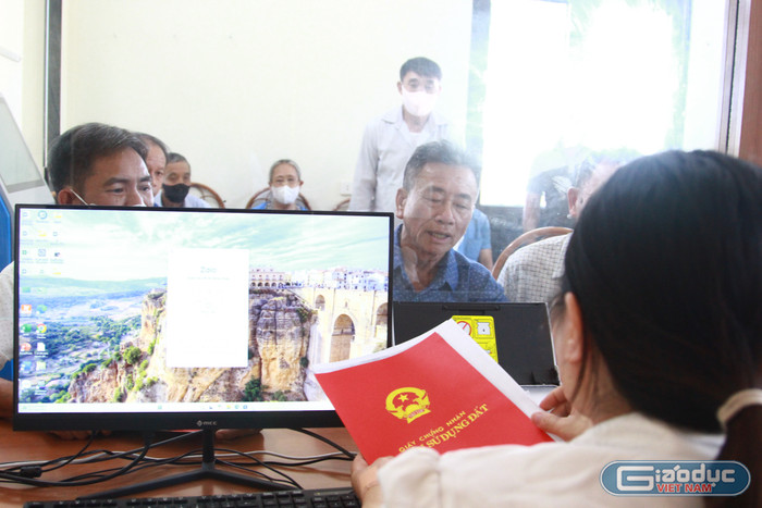 Ông Nguyễn Gia Ký được công chức Phạm Thị Thu Huyền tư vấn các thủ tục hồ sơ về tặng - cho đất cho hai người con trai.Ảnh: Mạnh Đoàn. gdvn-diem-phuc-vu-hanh-chinh-cong-xa-thuong-phuc-2.jpg