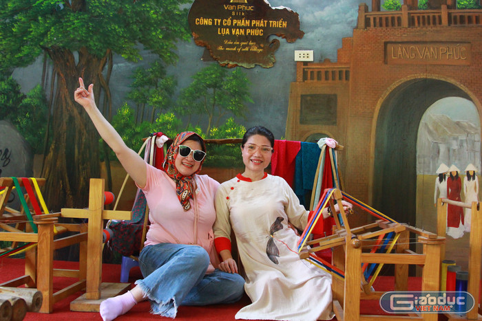 Chị Bùi Ánh Nguyệt (bên trái ảnh) chụp ảnh lưu niệm cùng người bạn bên mô hình dệt lụa xưa. Ảnh: Mạnh Đoàn gdvn-lang-lua-van-phuc-ha-dong-8.jpg