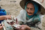 Một phụ nữ đi xe máy "giúp” cụ bà 10.000 đồng rồi giật ví