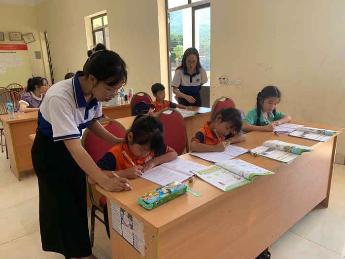 Hai sinh viên Trường Đại học Hạ Long và các học sinh tại "lớp học 0 đồng". Ảnh: NVCC z6871674917144-0d53e9930082db28bee652420590d0f7.jpg
