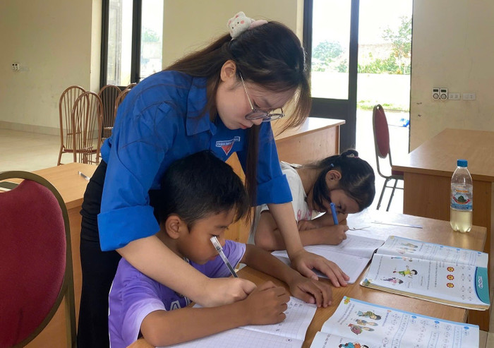 Hai sinh viên Khoa Sư phạm, Trường Đại học Hạ Long tận tình hướng dẫn các em nhỏ. Ảnh: NVCC 526207919-724773597069212-8543394935656839116-n.jpg