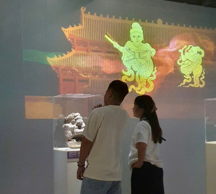 Khách tham quan trải nghiệm công nghệ trong Trưng bày chuyên đề “Vũ khúc Thiền môn - Nghệ thuật Phật giáo thời Lý: Di sản và công nghệ”. Ảnh: VNMH 499706083-1021588226844311-9141310129268691143-n.jpg