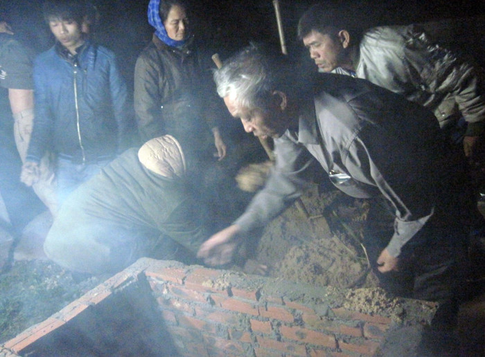 Những người thợ hồ làm việc trong đêm để kịp giờ đẹp làm lễ hoàn thành việc cải táng.