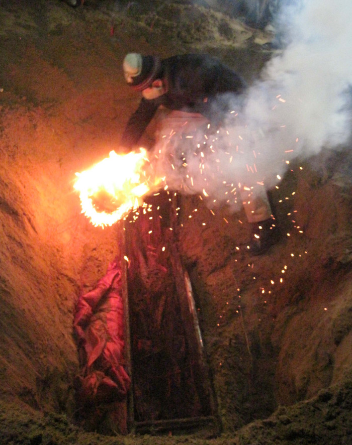 Người thợ nhặt xương đốt chổi sau khi mở nắp quan tài. Theo quan niệm dân gian, thì việc đốt chổi nhằm xua đuổi tà khí. Còn theo khoa học, việc này nhằm để xua đi những chất trong cơ thể đã phân hủy và không khí ngột ngạt.