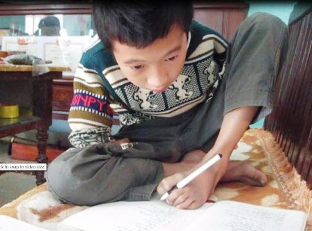 Hưng viết chữ bằng chân trái rất đẹp và luôn là học sinh giỏi, học sinh tiến tiến. Ảnh LP