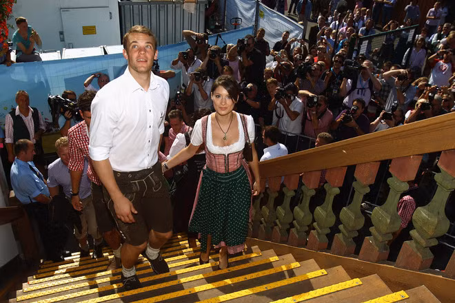 Manuel Neuer dẫn đầu đoàn quân Bayern trong hàng trăm con mắt ngưỡng mộ. Bên cạnh anh là bạn gái Katrin