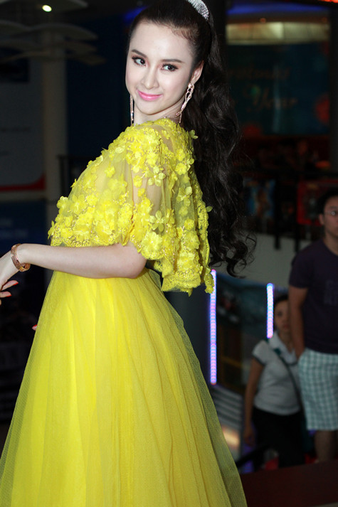 Cách tạo dáng để chụp hình của Angela cũng không được tự nhiên, khuôn mặt cô có vẻ căng thẳng