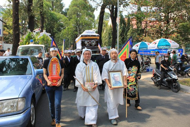 Anh trai cầm bát hương còn đạo diễn Nguyễn Quang Dũng cầm di ảnh người cha kính yêu trong nghi thức di quan