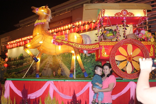 Nhiều người thích thú chụp ảnh bên chú ngựa đang kéo cổ xe được trang trí công phu với những đường nét hoa văn độc đáo