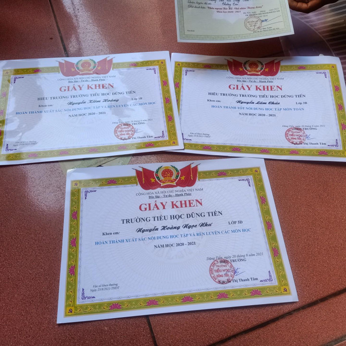 Giấy khen của ba đứa con chị Bến, cùng những phần thưởng là 20-30 nghìn đồng được chị cất giữ cẩn thận. (Ảnh: Nguyễn Nhất)