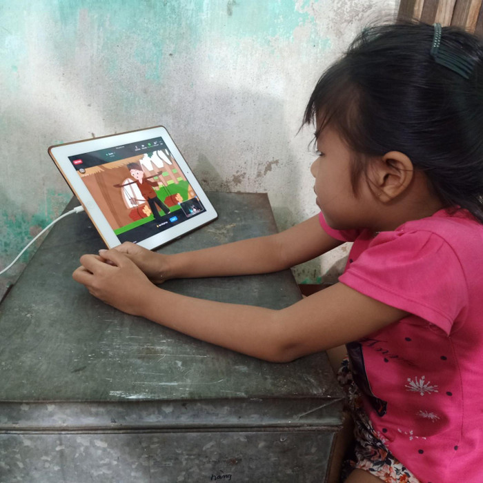 Đứa con út của chị Bến đi học nhờ nhà hàng xóm, khi đi học thì bé vác cái hòm để làm bàn học (Ảnh: Nguyễn Nhất)