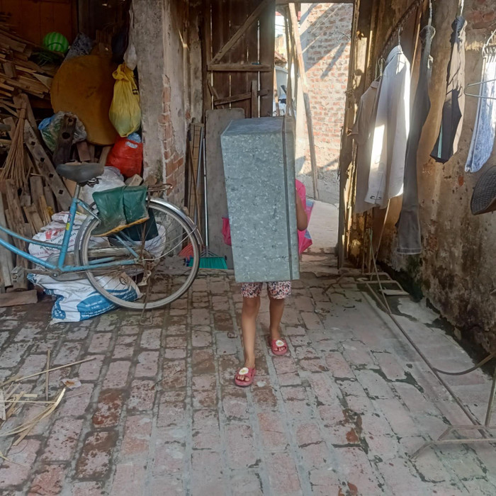 Cô con gái út của chị Bến vất vả khiêng chiếc hòm từ nhà hàng xóm về, sau khi kết thúc buổi học online.