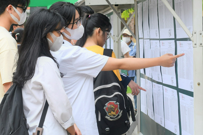 Em Phạm Minh Ngọc cùng em Nguyễn Trà Mi đang theo dõi danh sách phòng thi tại Điểm thi Trường Trung học phổ thông Phan Huy Chú – Đống Đa. (Ảnh: Ngọc Mai).