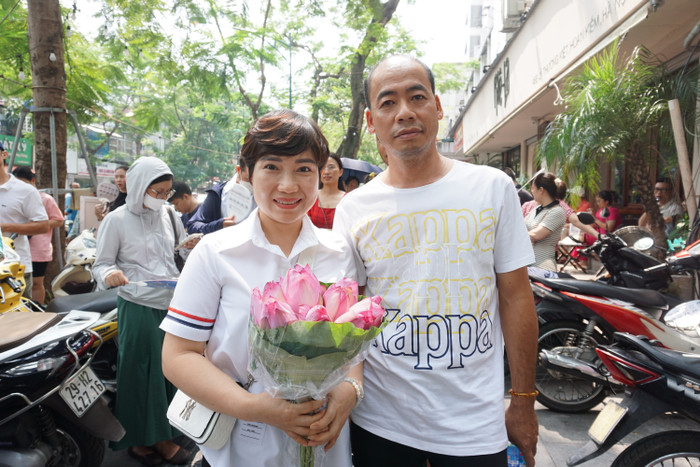 Vợ chồng chị Xuân Thảo đứng đợi con gái làm bài thi trong tâm trạng hồi hộp. Ảnh: Phạm Minh