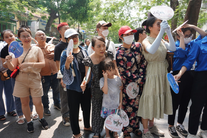 Em nhỏ cùng bố mẹ chờ đợi để đón anh chị của mình. Ảnh: Phạm Minh