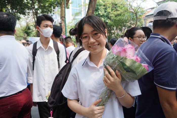 Học sinh Hiền Anh hạnh phúc vì hoàn thành bài thi tốt và được bố mẹ tặng hoa sen mình yêu thích. Ảnh: Phạm Minh