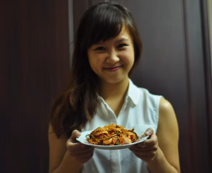 " Kim chi là một món ăn tuyệt vời của đất nước xứ Hàn lạnh giá, đặc biệt dùng Kim chi ăn kèm với thịt quay, hay đồ mỡ thì quả thật là hết ý. Trời chuyển lạnh làm một bát canh Kim chi cũng vô cũng hấp dẫn. Thi thoảng tôi hay vào bếp làm món ăn này cho mọi người trong gia đình cùng thưởng thức. Cách làm rất đơn giản: Hành lá rửa sạch, đầu hành thái sợi hoặc cắt khúc nhỏ đập dập, lá cho vào nước muối ngâm cải từ tối hôm trước. Củ cải bào sợi cho vào thau nước muối luôn. Hành lá, củ cải, cà rốt thái sợi sau khi ngâm sơ nuớc muối đem xả lại bằng nước lạnh rồi vắt khô. Pha nước muối sao cho hơi mặn, đổ ngập cải, lấy đồ nặng dằn lên. Thường tối ngâm sáng xả nước để ráo là vừa. Cải sau khi ngâm qua vớt ra xả sơ bằng nước lạnh rồi để vào rổ cho thật ráo nước. Nước gừng + nước tỏi (hoặc tỏi xay) + nước mắm + đường + bột ngọt chứa tinh chất Umami pha làm sao nếm ngon và dậy mùi thơm. Sau khi nêm nếm nước pha vừa miệng, cho 1 muỗng canh dầu mè và 1 muỗng hạt mè vào trộn đều rồi cho 3 muỗng ớt màu của Korean vào. Cho hành, gừng thái sợi và củ cải, cà rốt thái sợi vào trộn, sau đó, trộn tất cả các gia vị đó vào từng tép cải cho đều. Cuối cùng, cho Kim chi vào hộp đóng kín lại để ở ngoài 1 đêm rồi cho vào tủ lạnh ăn dần..Món ăn này là món khoái khẩu của cả gia đình tôi, nó làm tan đi cái gia lạnh của mùa đông năm nay...".