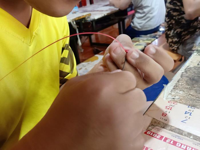 Công đoạn cuốn giấy cuộn của các em để làm nên những sản phẩm thủ công đẹp mắt như chiếc giỏ mini, con thú... (Ảnh: Mạnh Đoàn)