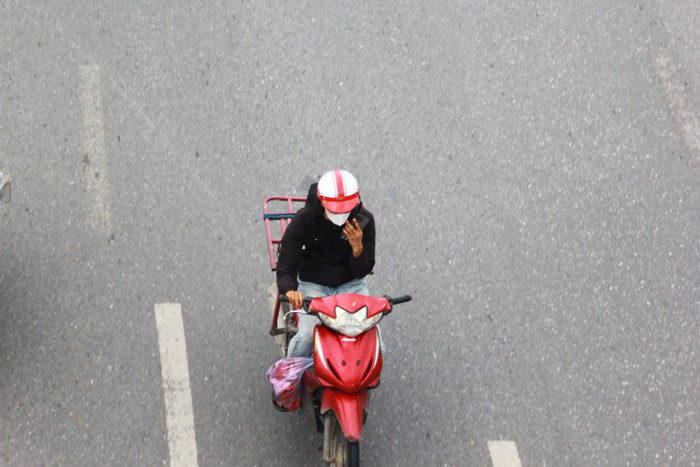 Một tài xế điều khiển xe bằng một tay, tay kia sử dụng điện thoại di động. (Ảnh: Mạnh Đoàn) gdvn_tai-xe-su-dung-dien-thoai-khi-di-duong (5).JPG