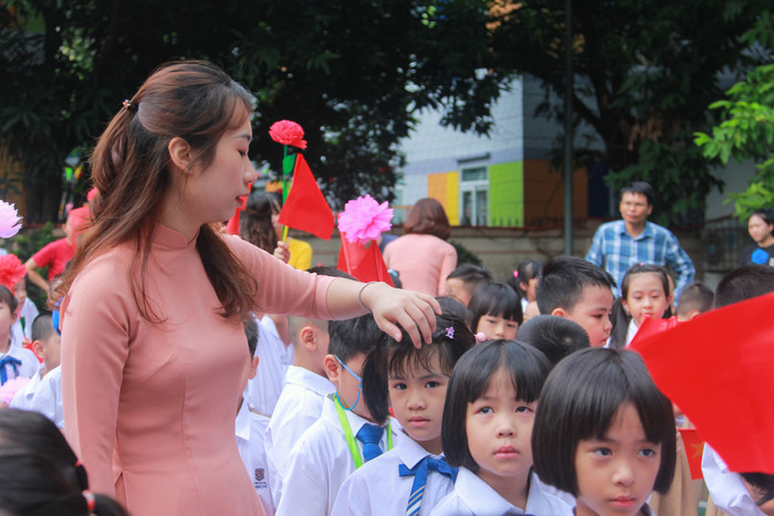 Giáo viên chủ nhiệm vén mái tóc của học trò mướt mồ hôi. Giáo viên chủ nhiệm vén mái tóc của học trò mướt mồ hôi.