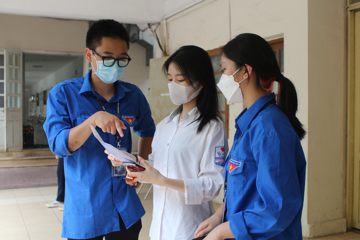 Tình nguyện viên hỗ trợ thí sinh tìm kiếm phòng thi. (Ảnh: Phạm Minh)