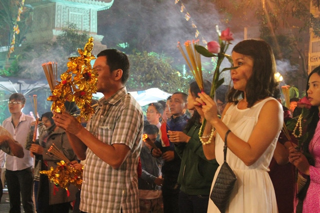 Nhiều người cầm những cành lộc, cành bông trên tay để vào chùa xin lộc, cầu phúc