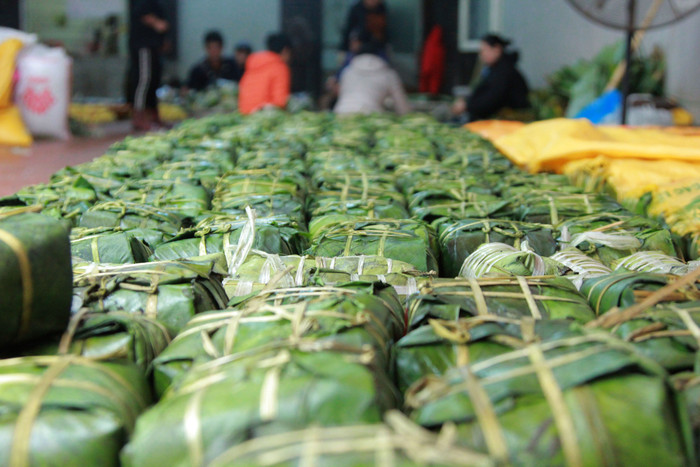 Ngay từ đầu cổng, hàng trăm chiếc bánh chưng đã được luộc chín xếp ngăn nắp trên giá gỗ. (Ảnh: Mạnh Đoàn) Ngay từ đầu cổng, hàng trăm chiếc bánh chưng đã được luộc chín xếp ngăn nắp trên giá gỗ. (Ảnh: Mạnh Đoàn)