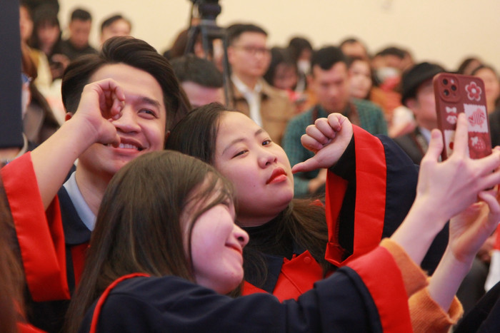 Sinh viên phấn khởi chụp ảnh lưu niệm trước giờ lên nhận bằng tốt nghiệp.