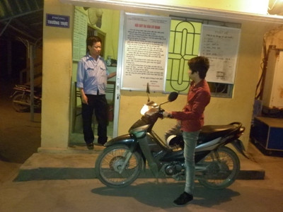 Chú Lê Văn Tiến (nhân viên bảo vệ trường Cao Đẳng nghề cơ điện Hà Nội) đang kiểm tra sinh viên ra vào trường, trong ca trực đêm của mình (Ảnh: Nga Trịnh)