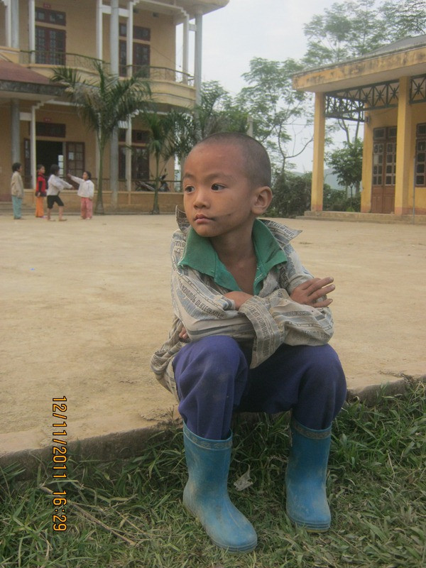 Em Chiến, một học sinh tiểu học xã Kim Bon lặng lẽ nhìn các bạn nô đùa Em Chiến, một học sinh tiểu học xã Kim Bon lặng lẽ nhìn các bạn nô đùa