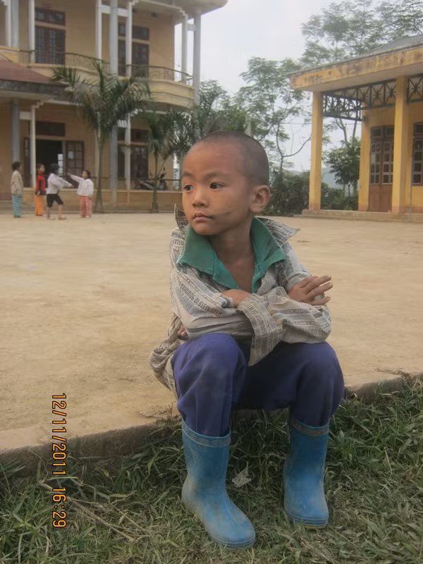 Em Chiến, một học sinh tiểu học xã Kim Bon lặng lẽ nhìn các bạn nô đùa