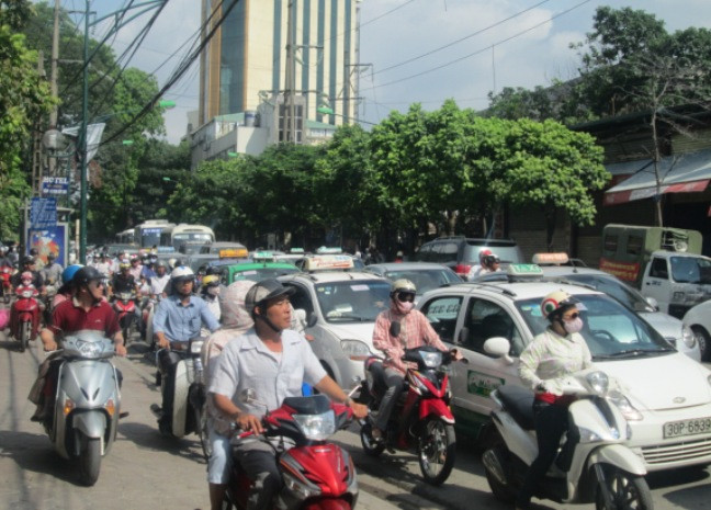 Người đi đường dừng lại hoặc di chuyển chậm chạp để chứng kiến khung cảnh tan hoang của cây xăng sau đám cháy. Người đi đường dừng lại hoặc di chuyển chậm chạp để chứng kiến khung cảnh tan hoang của cây xăng sau đám cháy.