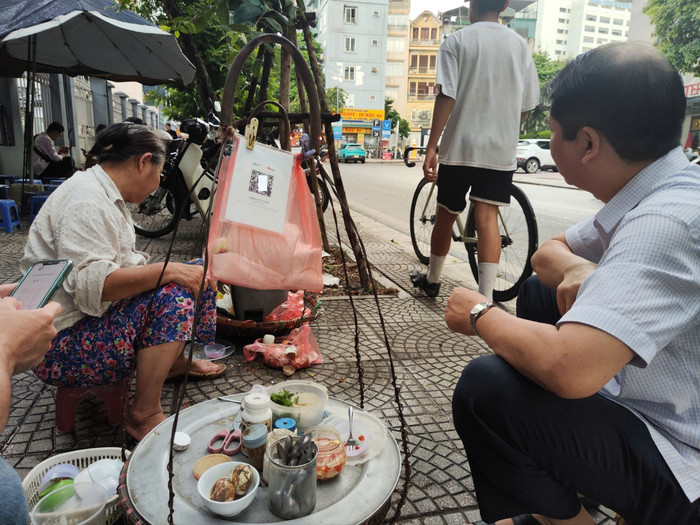 Gánh hàng rong của bà Thu được nhiều khách lựa chọn vì có mã QR chuyển khoản nhanh chóng. Ảnh: Minh Ngọc z6917382668244-946a717ed9637fdfe7705dd6436be8d4-9386.jpg