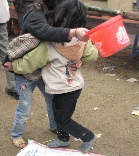 Khó cầm lòng trước cảnh hai em nhỏ ôm nhau khóc xin tiền. (ảnh: Cao Tuân)