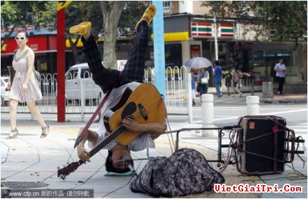Màn biểu diễn kỳ lạ và độc đáo của nghệ sĩ ở một quảng trường tại thành phố Quảng Châu, tỉnh Quảng Đông ngày 20/5 làm người đi đường tò mò.