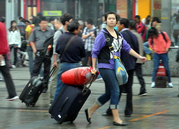 Một cô gái kéo hành lý ra khỏi nhà ga xe lửa Trịnh Châu, thủ phủ tỉnh Hà Nam, Trung Quốc Một cô gái kéo hành lý ra khỏi nhà ga xe lửa Trịnh Châu, thủ phủ tỉnh Hà Nam, Trung Quốc