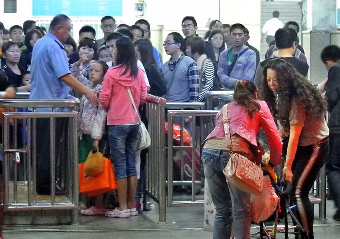 Chen chúc nhau qua cửa soát vé