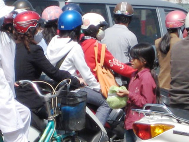 Tại một số giao lộ lớn như: Ngã tư Sở, ngã tư Vọng, Chùa Bộc - Thái Hà… luôn có sự “hiện diện” của những em nhỏ tầm tuổi từ 8 - 12 trong “vai trò” ăn xin với phương thức hoạt động “liên hồi” theo tín hiệu đèn chỉ dẫn giao thông: Đèn đỏ xin tiền, đèn xanh thì tạm nghỉ? (Ảnh: Châu Như Quỳnh) Tại một số giao lộ lớn như: Ngã tư Sở, ngã tư Vọng, Chùa Bộc - Thái Hà… luôn có sự “hiện diện” của những em nhỏ tầm tuổi từ 8 - 12 trong “vai trò” ăn xin với phương thức hoạt động “liên hồi” theo tín hiệu đèn chỉ dẫn giao thông: Đèn đỏ xin tiền, đèn xanh thì tạm nghỉ? (Ảnh: Châu Như Quỳnh)