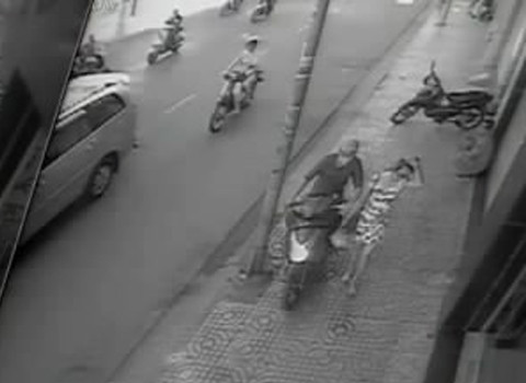 Tên cướp chạy xe máy liều lĩnh leo lên vỉa hè, lách qua cột đèn lao đến bên cô gái.