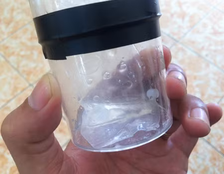 Hạt lạ chứa trong túi nhờn đặt trong áo ngực trông như hạt cườm nhỏ bằng đầu đũa. Ảnh: Thiên Chương
